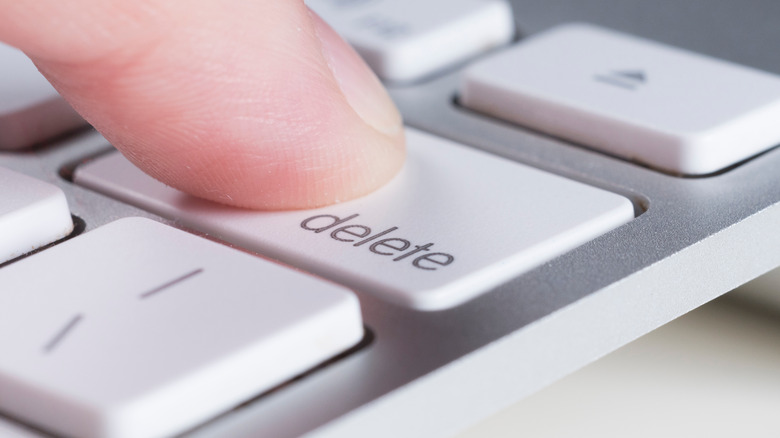 Extreme closeup of finger pressing delete key