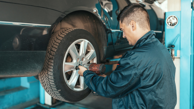 mechanic tightening tire bolts