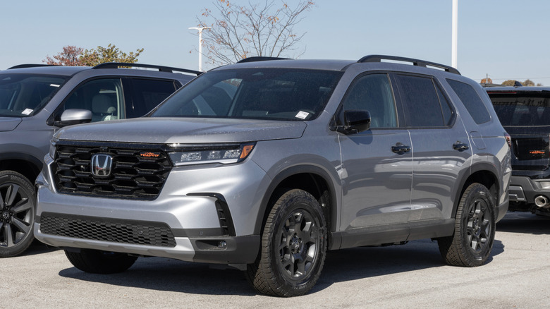A gray Honda Pilot in a lot