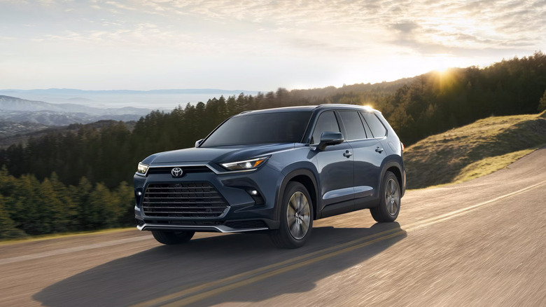 A blue Toyota Grand Highlander driving on the mountainside