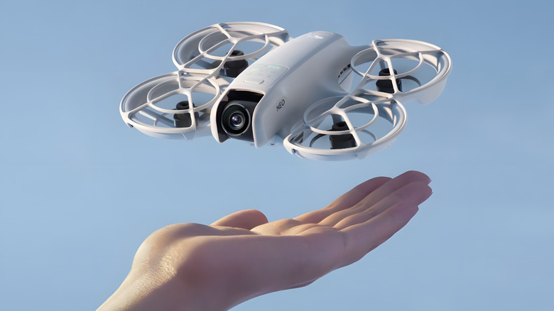 DJI Neo above someone's hand, blue sky background