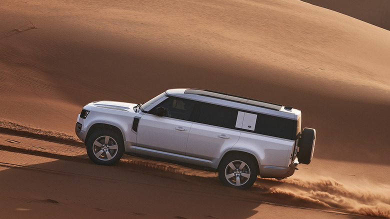 2025 Land Rover Defender 130 on sand dunes side view