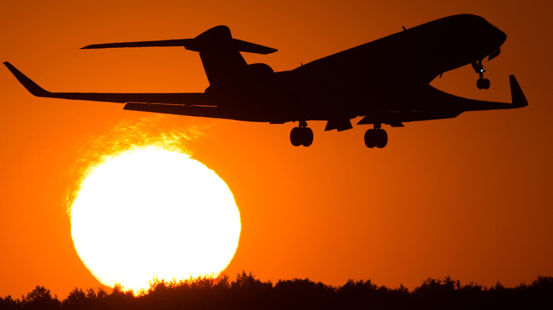 Executive jet taking off aa the sun sets.