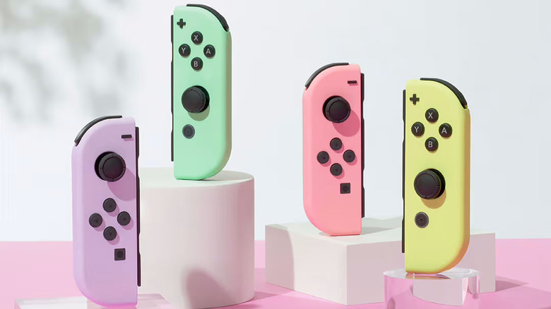 Four pastel Joy-Cons on a stylized pink surface