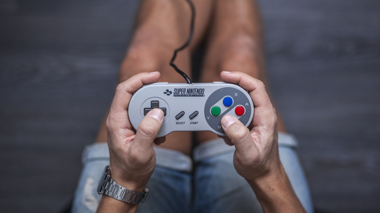 A person holding the SNES controller