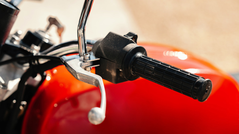 Closeup of a motorcycle handlebar with the clutch cable visible