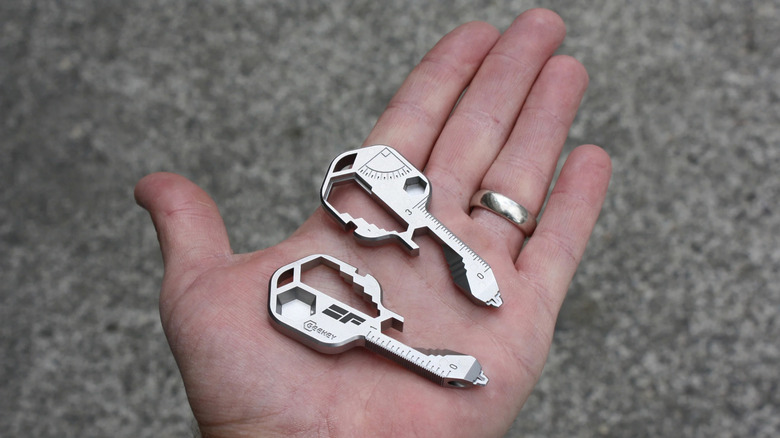 Two Geekey multitools on the palm of a person's hand