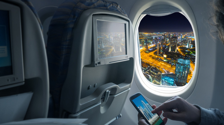person smartphone airplane flying Dubai