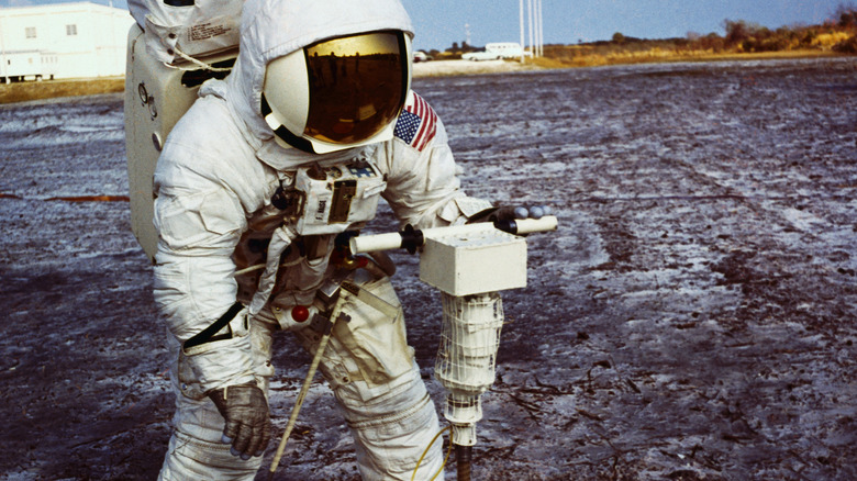 astronaut demonstrates lunar drill