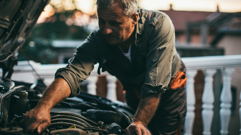 man repairing car