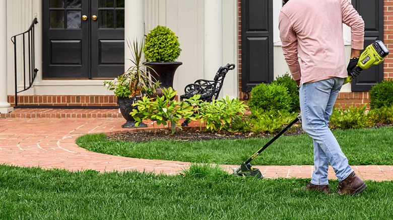 trimming edges of grass with Ryobi trimmer