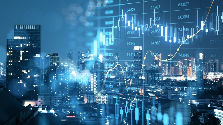 glowing big data forex candlestick chart on blurry city backdrop