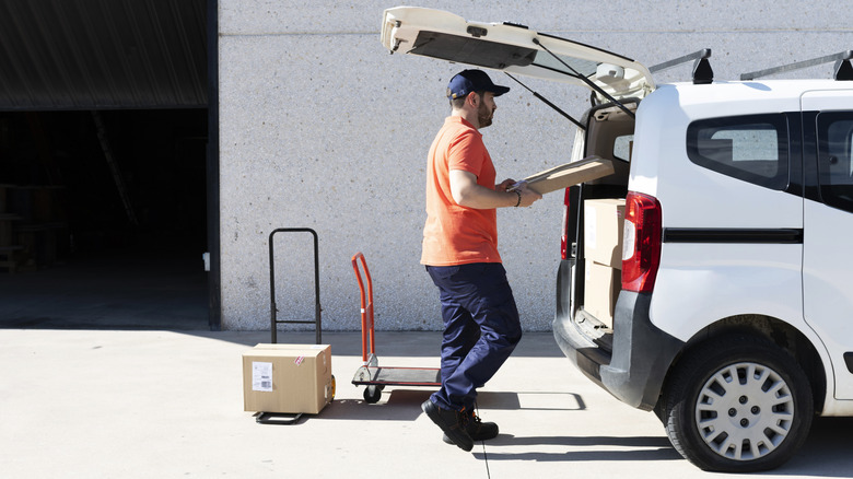 A person loading packages into an SUV
