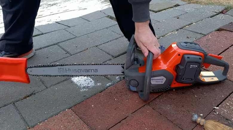 Person putting sheath on chainsaw blade
