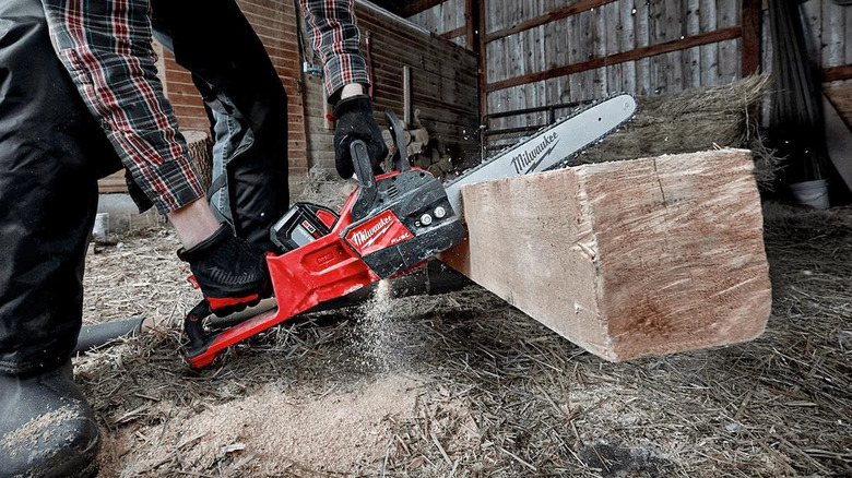 Person cutting lumber with chainsaw
