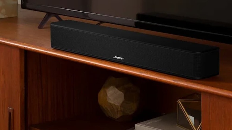 A Bose Solo Soundbar 2 under a TV on a TV stand.