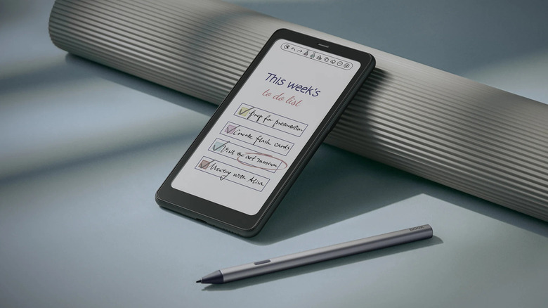 The Boox Palma 2 Pro e-reader propped up, next to a pen
