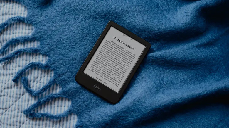 The Kobo Clara BW e-reader on a bed with a blue sheet