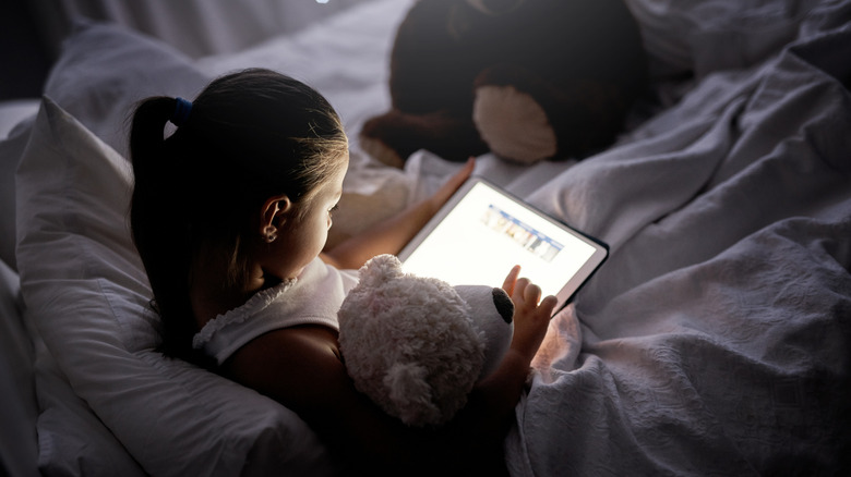 Girl reading in bed on a tablet