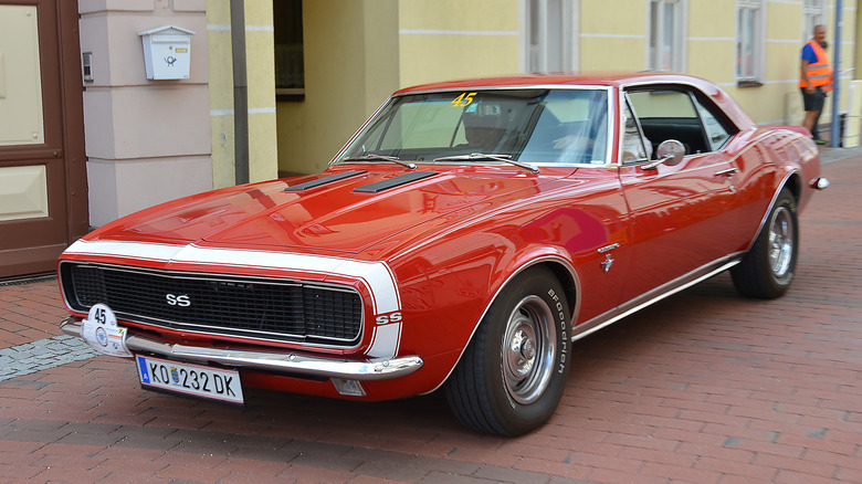 A red Chevrolet Camaro on a brick road