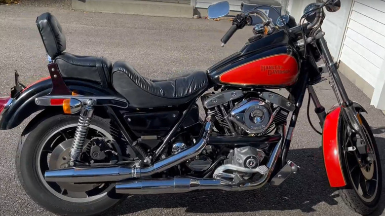 A 1982 FXR Super Glide Mark II motorbike being displayed outside a garage