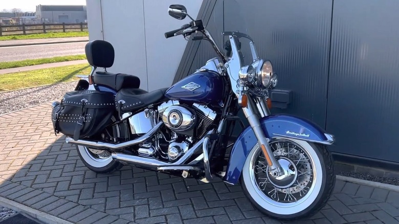 A blue Harley-Davidson Heritage Softail Classic (2015) parked in a parking space