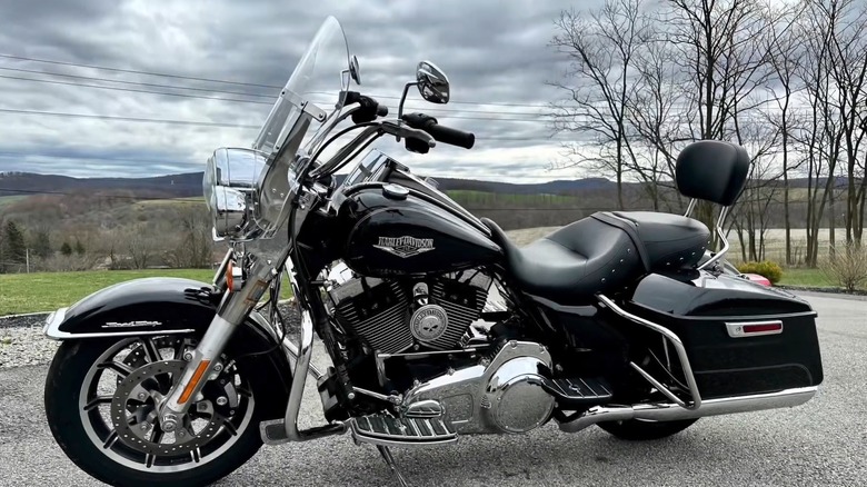 A black Harley-Davidson Road King (2016) parked in the parking area