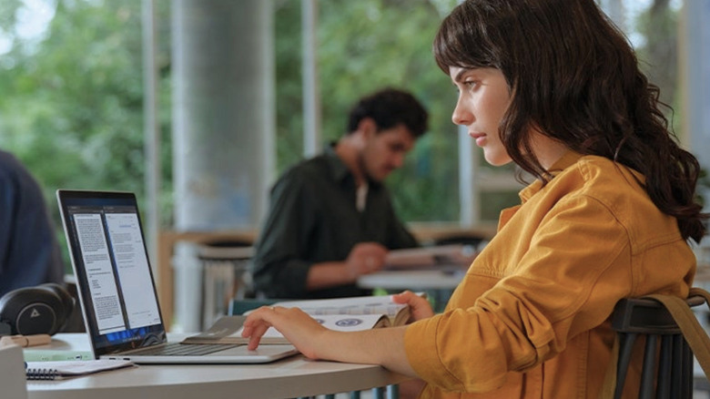 A woman using the HP OmniBook 5 at a table.