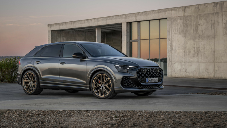 2025 Audi RS Q8 photographed in front of a minimalist house front 3/4 view