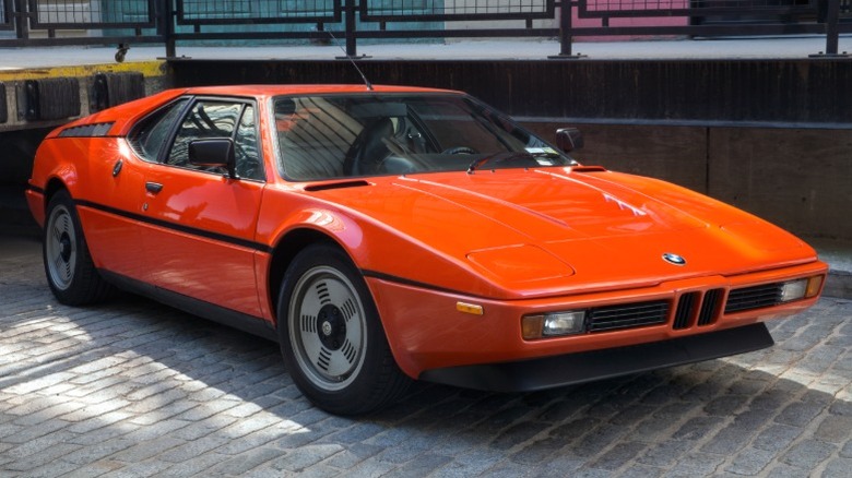 Red BMW M1 parked on gray bricks