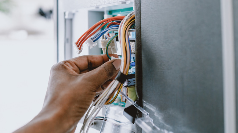 hand grabbing electrical wires
