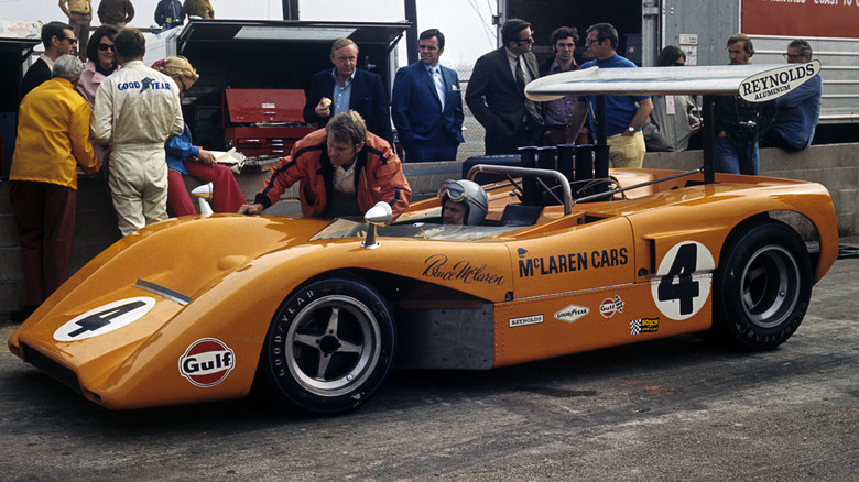 Orange McLaren vintage race car in pits