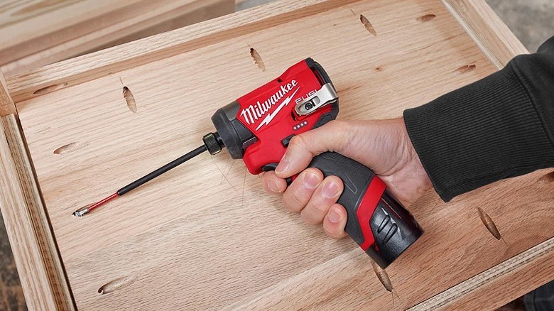 Using a hex impact driver on a wooden structure.