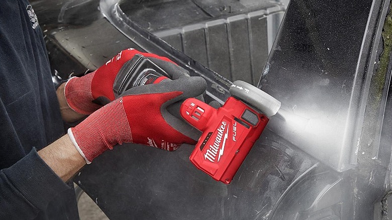 Using a cut off tool on the edges of a vehicle.