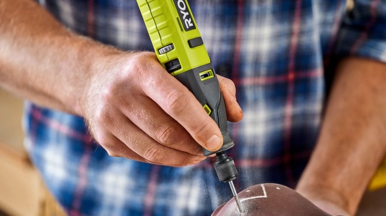 Person using a Ryobi USB Lithium Rotary Tool Kit to carve a design on a pot