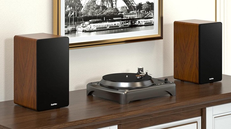 A pair of bookshelf speakers kept on either side of a turntable