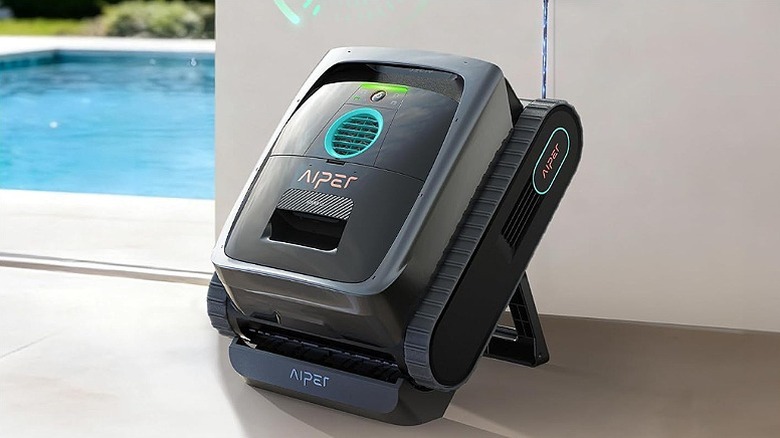 Black Aiper pool robot docked to a charging station.