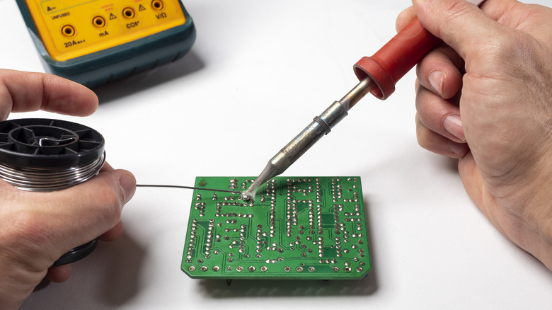 A person soldering a component onto a PCB