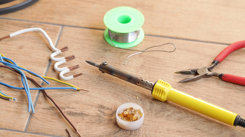 A soldering iron with solder, flux, and wires