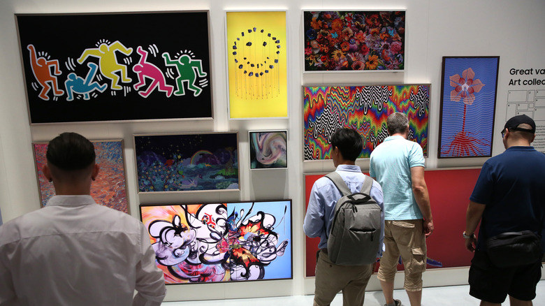 A wall of Samsung The Frame TVs with a variety of art images.
