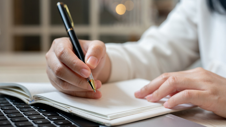 Worker with laptop, pen, and paper