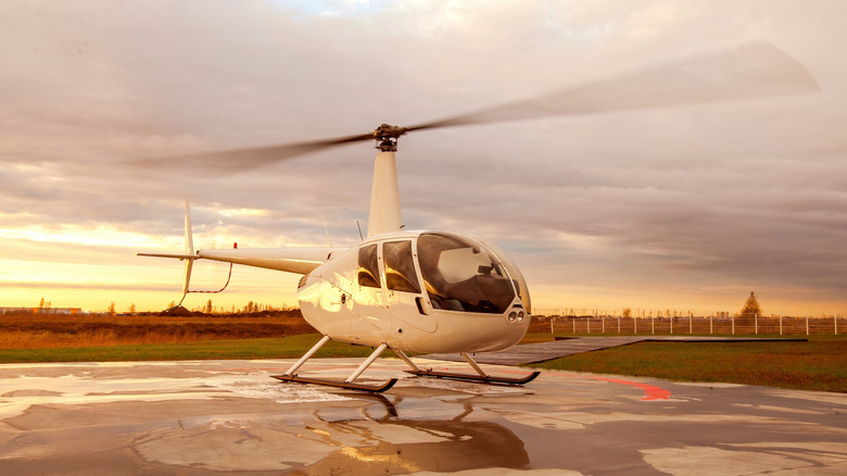 White helicopter on landing pad at sunset