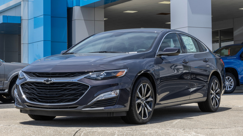 A gray Chevrolet Malibu parked in a dealership
