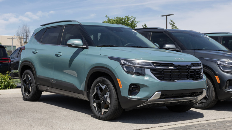 Blue-green Kia SUV parked