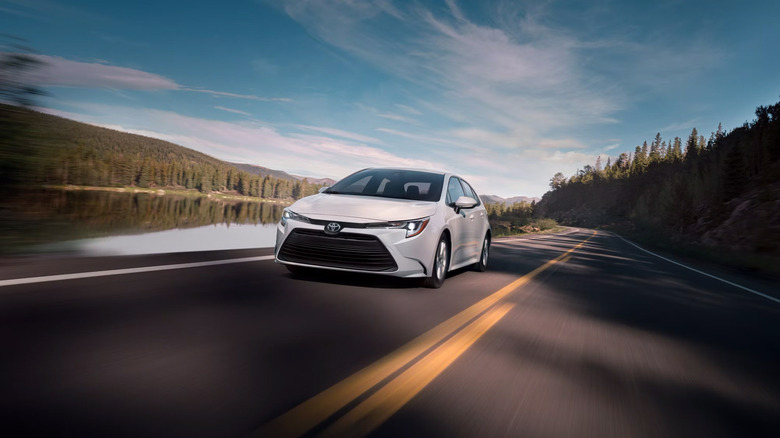 A white Toyota Corolla driving