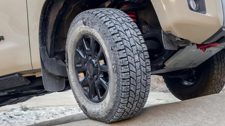 The Yokohama Geolandar A/T G015 all-terrain tires attached to an off-white vehicle