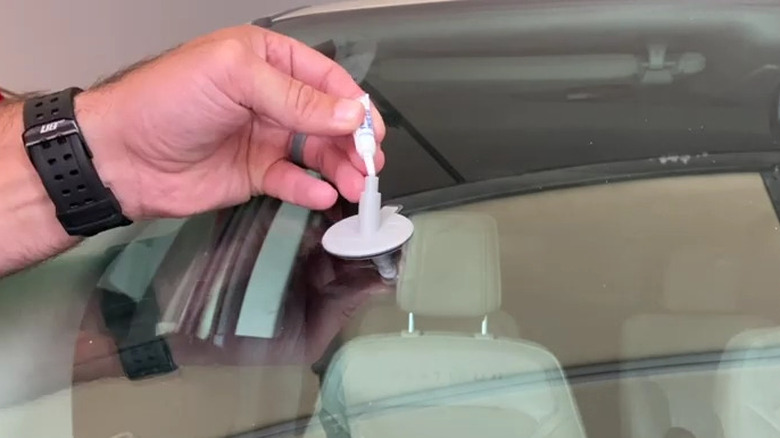 a windshield repair kit being applied to glass