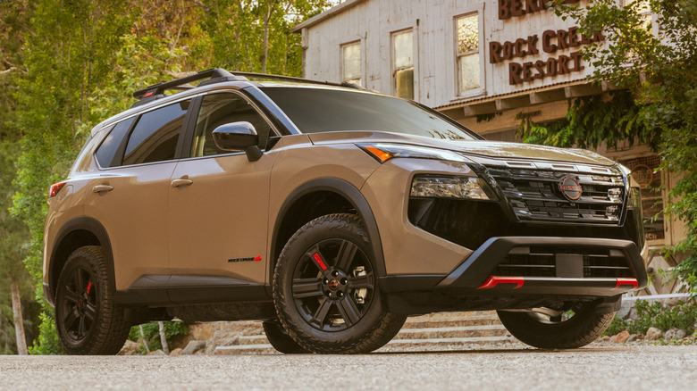 Brown Nissan Rogue parked in front of a building