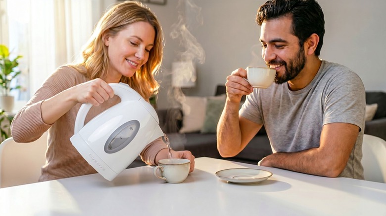 woman pouring water from Ovente Electric Kettle