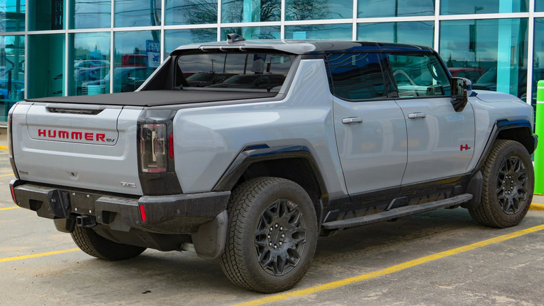 Gray GMC Hummer EV pickup truck seen from right rear